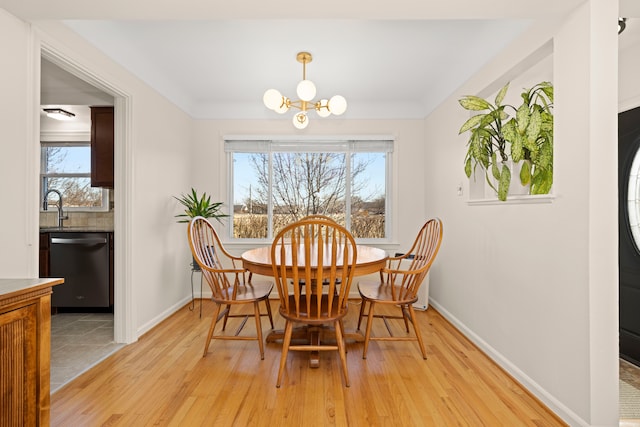 dining room with light wood-style flooring, a chandelier, and a wealth of natural light