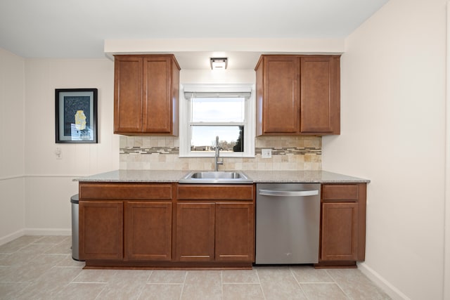 kitchen with a sink, brown cabinetry, backsplash, and stainless steel dishwasher