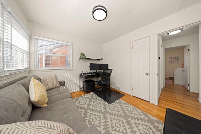 office space featuring baseboards, visible vents, and light wood-style floors