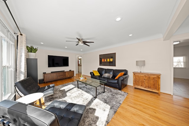 living room featuring light wood-type flooring, ceiling fan, baseboards, and recessed lighting