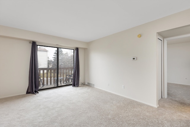 carpeted spare room featuring visible vents and baseboards