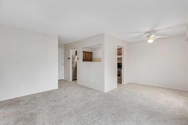 unfurnished room with light colored carpet, ceiling fan, and baseboards