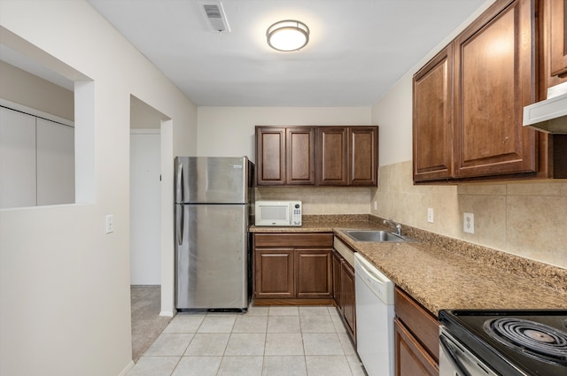 kitchen with light tile patterned floors, visible vents, decorative backsplash, a sink, and white appliances