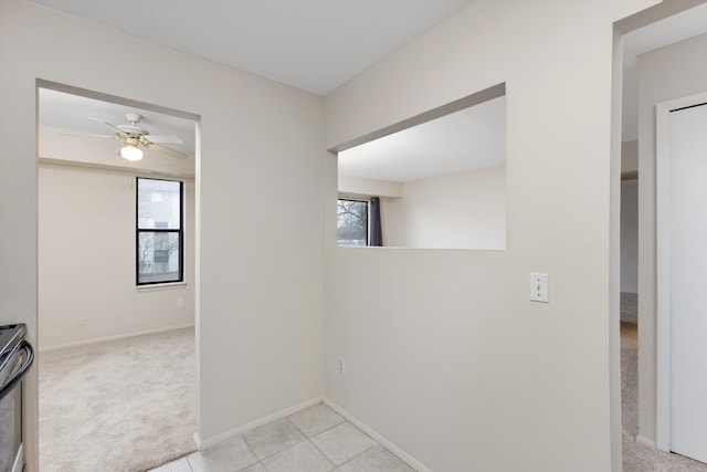 hallway featuring carpet flooring and baseboards