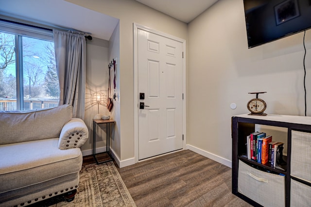 entrance foyer with dark wood-type flooring and baseboards