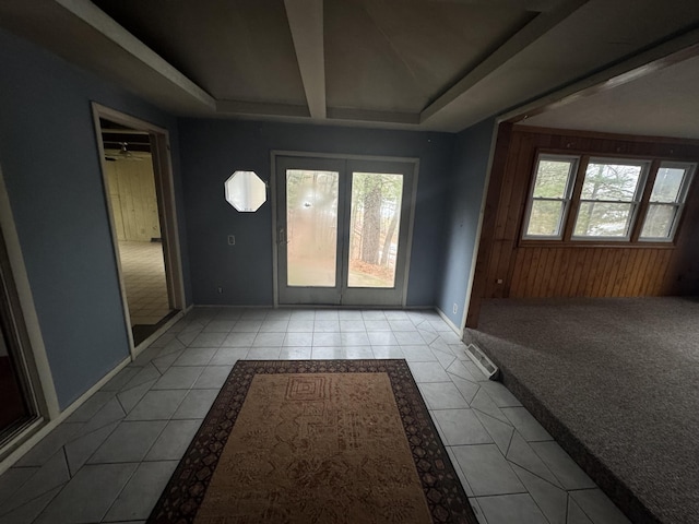 entryway featuring baseboards, carpet floors, and tile patterned floors