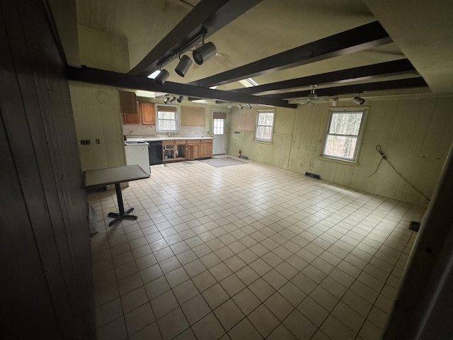 unfurnished living room featuring wooden walls, visible vents, beam ceiling, tile patterned floors, and track lighting