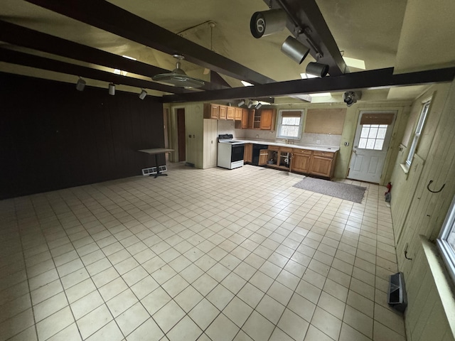 kitchen with range with electric stovetop, light tile patterned floors, light countertops, brown cabinetry, and open floor plan