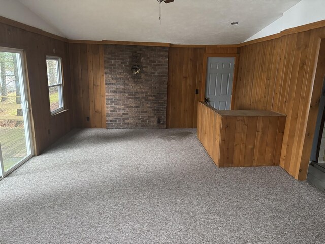 interior space with lofted ceiling, wooden walls, and carpet flooring