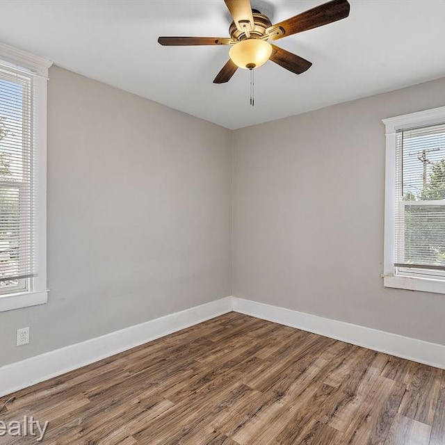 spare room featuring a ceiling fan, baseboards, and wood finished floors