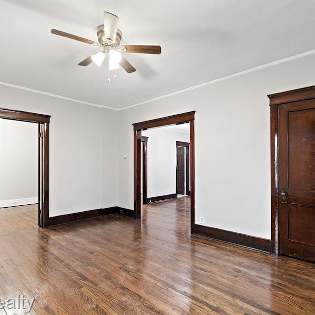 spare room with baseboards, ceiling fan, wood finished floors, and crown molding