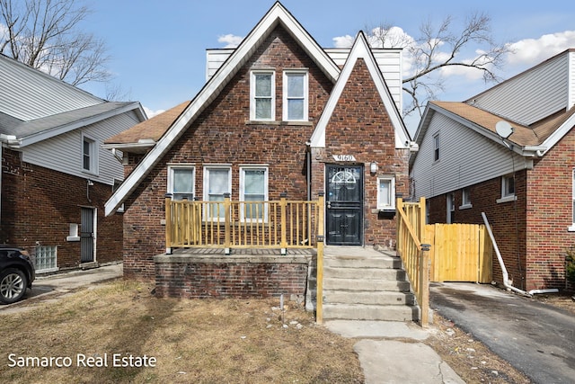 tudor home featuring brick siding