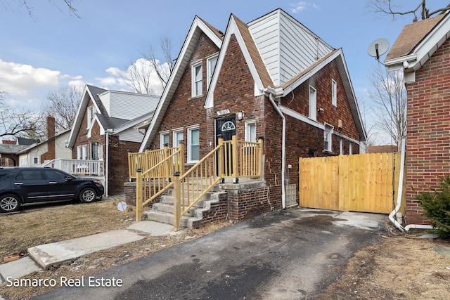 view of front of property featuring brick siding and fence