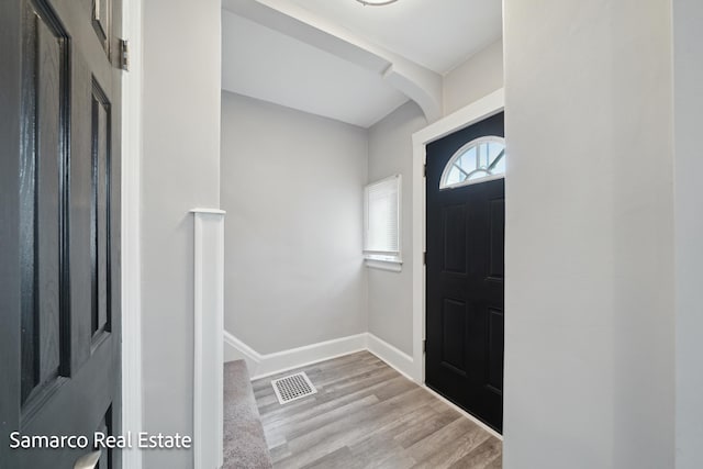 entrance foyer with baseboards, visible vents, and wood finished floors