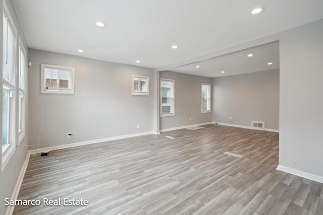 empty room featuring a wealth of natural light, light wood-style flooring, and recessed lighting