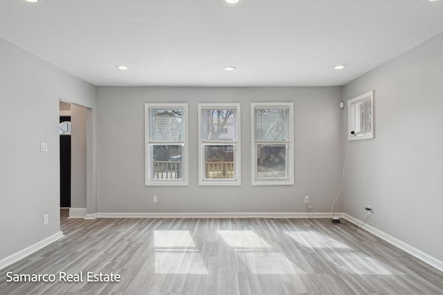 unfurnished room with recessed lighting, wood finished floors, and baseboards