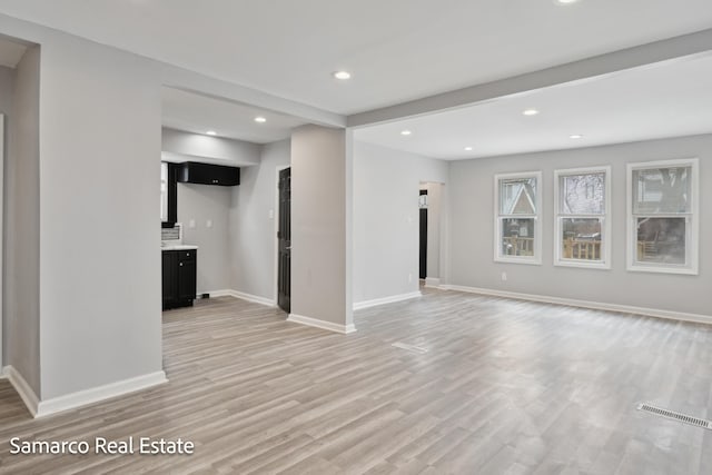 interior space featuring light wood finished floors, baseboards, visible vents, and recessed lighting