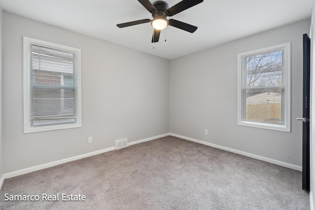 spare room with baseboards, visible vents, ceiling fan, and carpet flooring