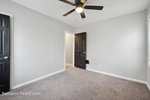 empty room featuring carpet floors, ceiling fan, and baseboards