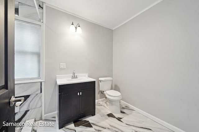 half bathroom featuring toilet, vanity, baseboards, marble finish floor, and ornamental molding