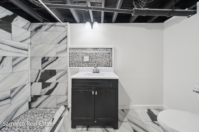 full bath with toilet, vanity, baseboards, marble finish floor, and a tile shower