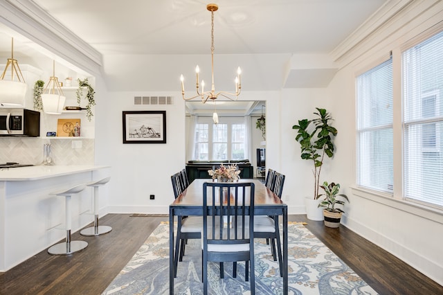 dining space featuring dark wood-type flooring, visible vents, and baseboards