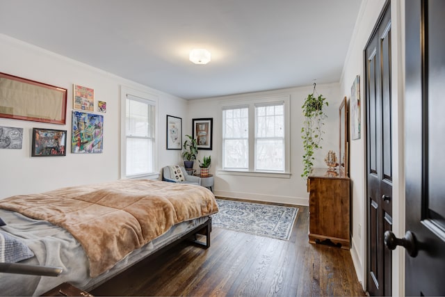 bedroom featuring multiple windows, baseboards, dark wood finished floors, and crown molding