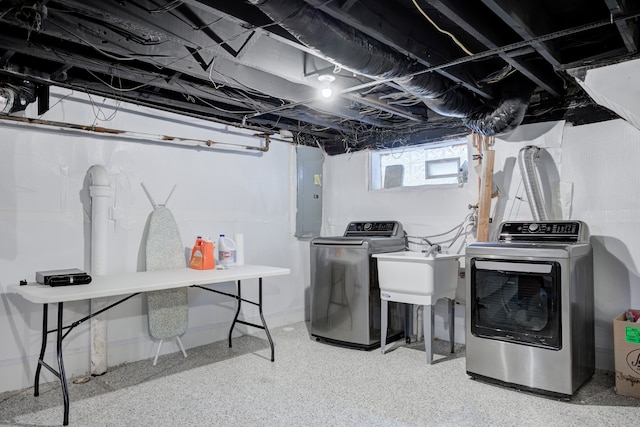 laundry area featuring laundry area, electric panel, washer and clothes dryer, and a sink