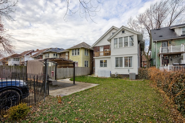 back of property featuring a residential view, cooling unit, fence, and a lawn