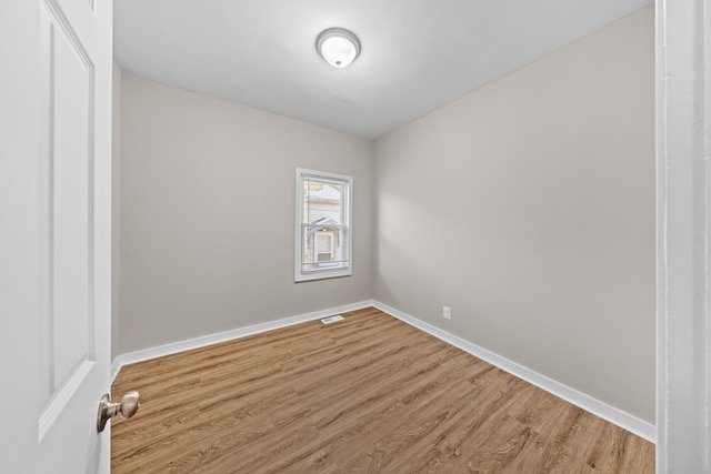 spare room with visible vents, light wood-style flooring, and baseboards