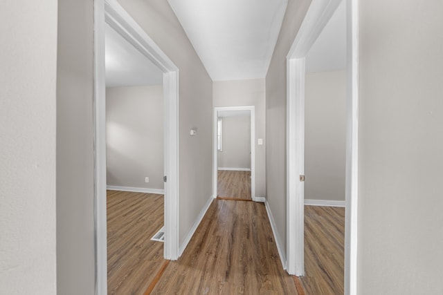 hallway featuring baseboards and wood finished floors