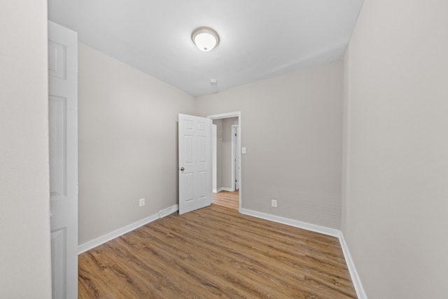 empty room featuring baseboards and wood finished floors