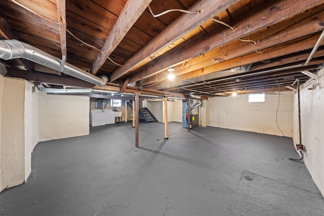 basement featuring heating unit and washing machine and clothes dryer