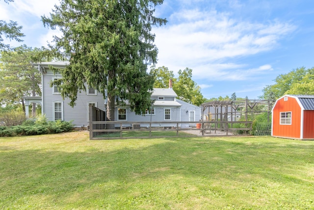 view of yard with a shed, an outdoor structure, and fence