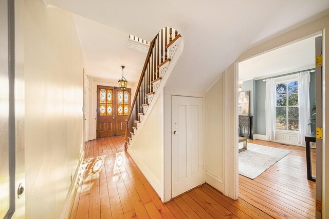 hall with light wood finished floors and stairs