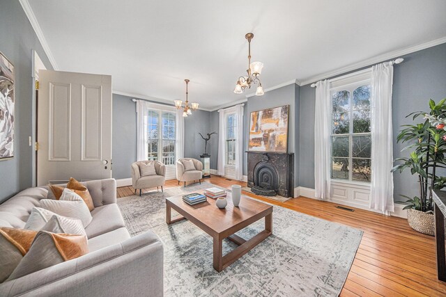 living area featuring ornamental molding, visible vents, and a notable chandelier