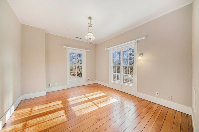 unfurnished dining area featuring hardwood / wood-style flooring, visible vents, baseboards, and crown molding