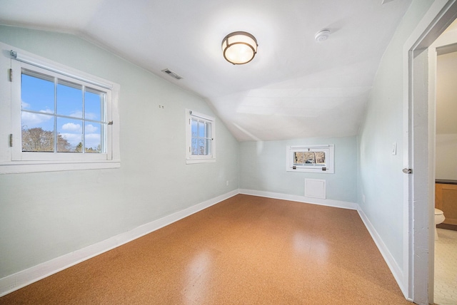 additional living space featuring vaulted ceiling, visible vents, and baseboards