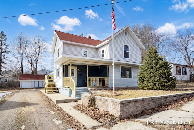 view of front of home with covered porch, roof with shingles, a detached garage, and an outdoor structure