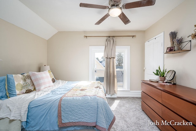 bedroom featuring lofted ceiling, a ceiling fan, and light colored carpet