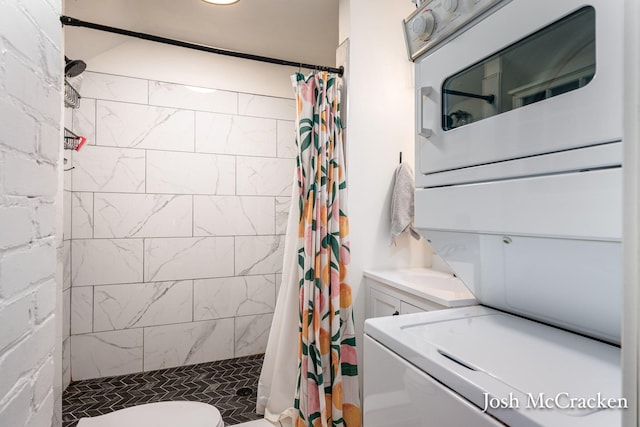 bathroom with stacked washer and dryer, a stall shower, and toilet