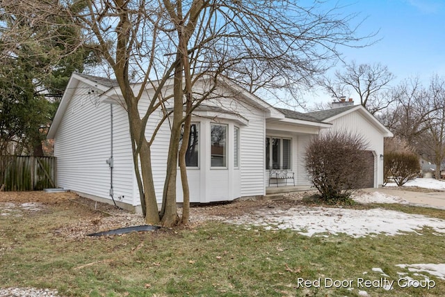 view of side of home featuring a garage, driveway, and fence