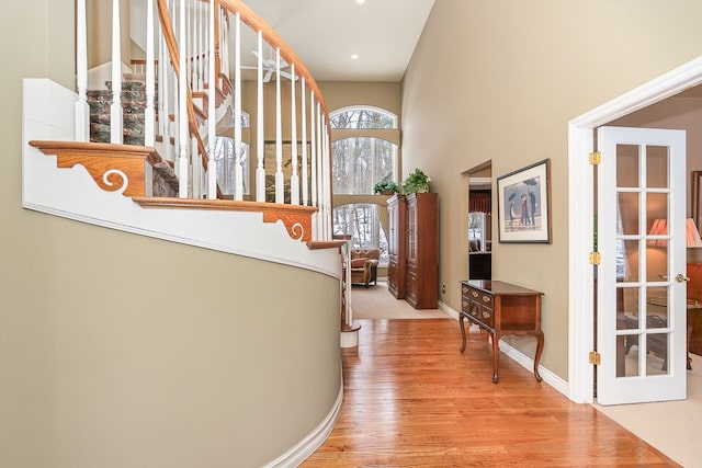 corridor with wood finished floors, baseboards, and stairs