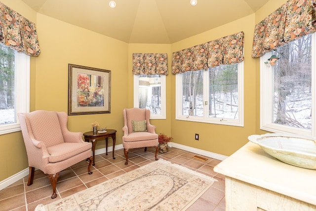 living area featuring vaulted ceiling, baseboards, visible vents, and tile patterned floors