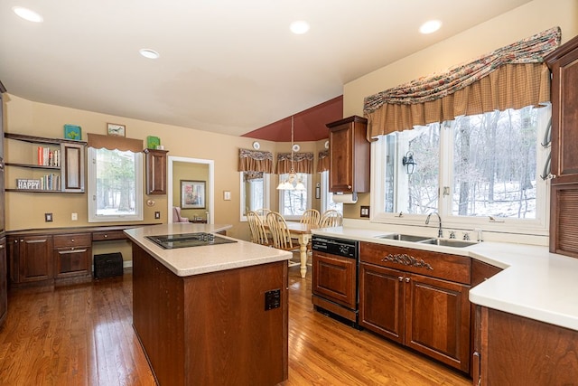 kitchen featuring paneled dishwasher, wood finished floors, a center island, black electric stovetop, and a sink