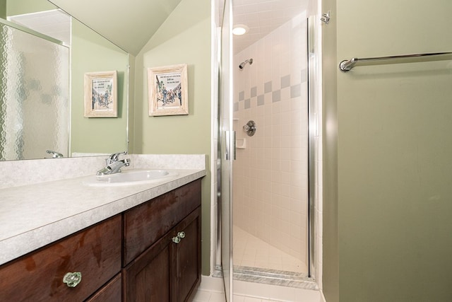 full bath with vaulted ceiling, a shower stall, and vanity