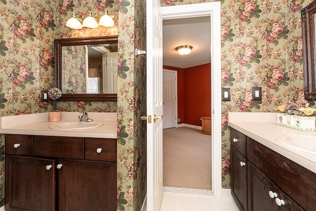 bathroom with two vanities, a sink, and wallpapered walls