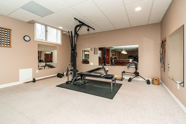 workout area featuring a drop ceiling, carpet flooring, and baseboards