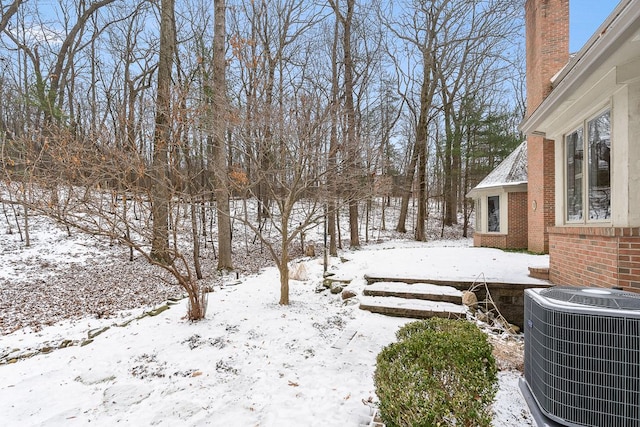 yard covered in snow featuring central air condition unit