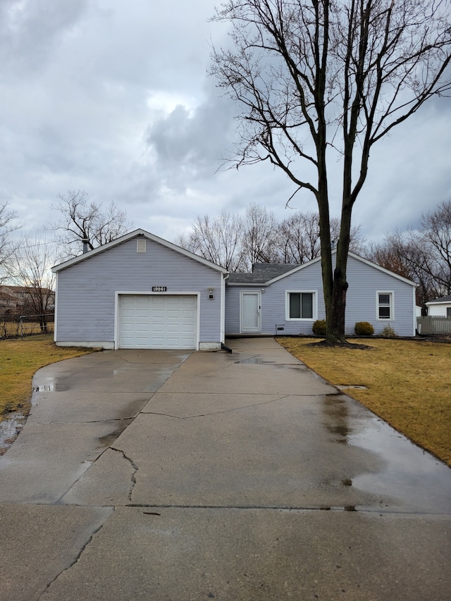 view of front of house featuring driveway, a front lawn, and fence